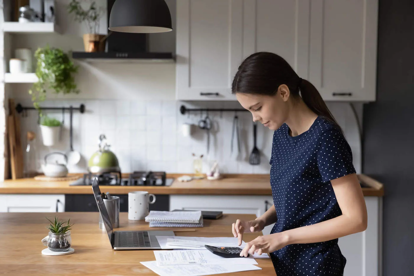 Woman calculating whether to use HELOC to pay off mortgage.