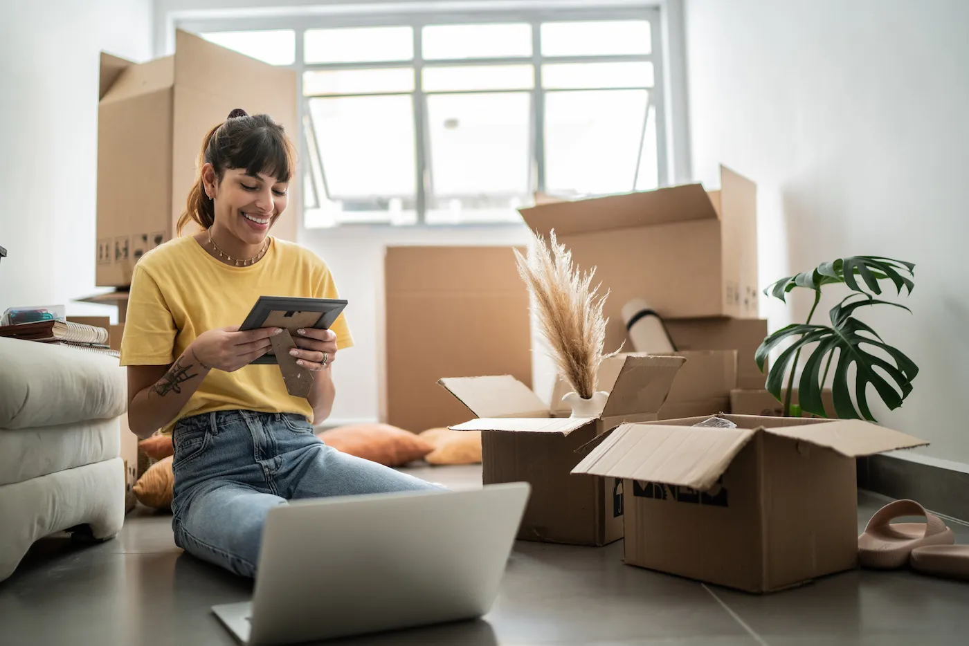 Young woman looking at a photo frame at new house