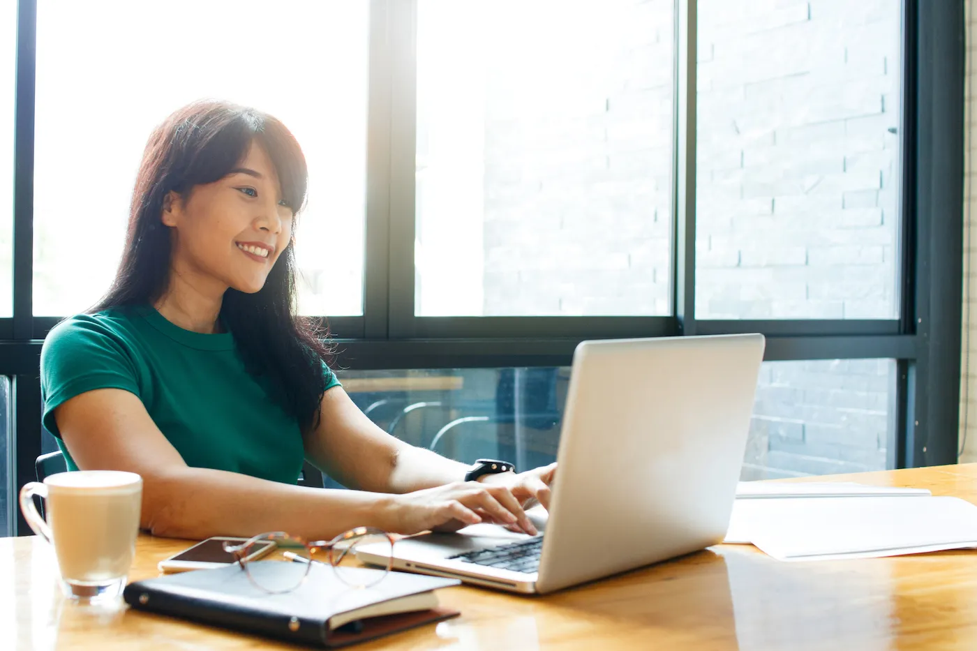 Woman looking at laptop in cafe, researching second chance banking