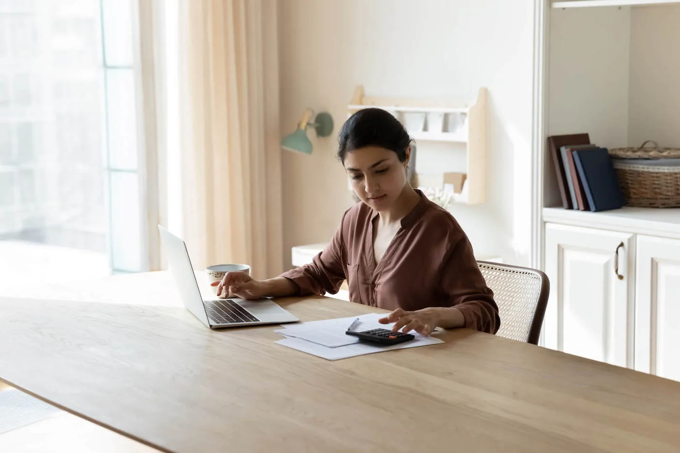 Woman seated at desk planning retirement funds.