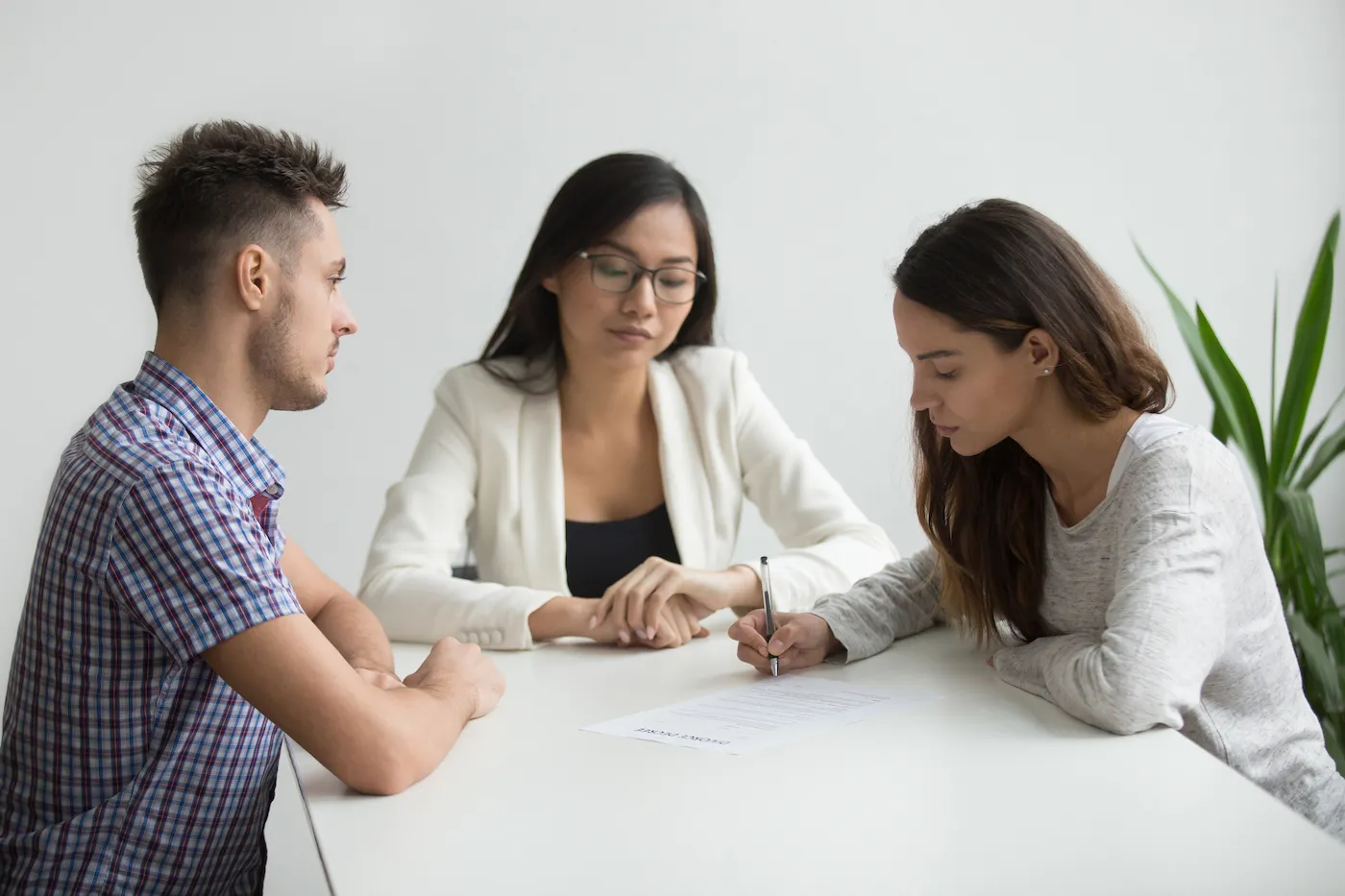 Woman signing papers with ex-husband