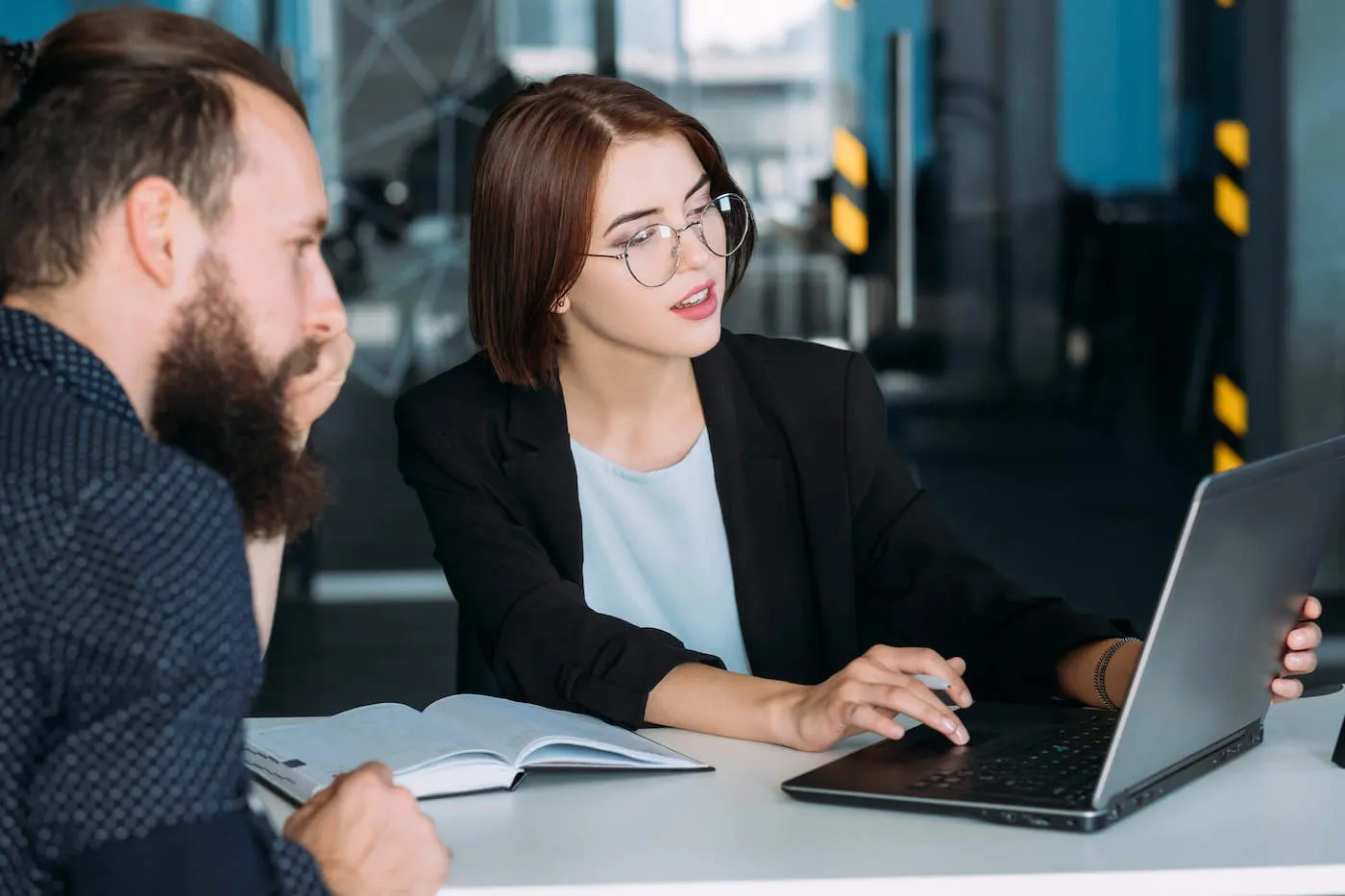 Young woman in business attire conversing with man.