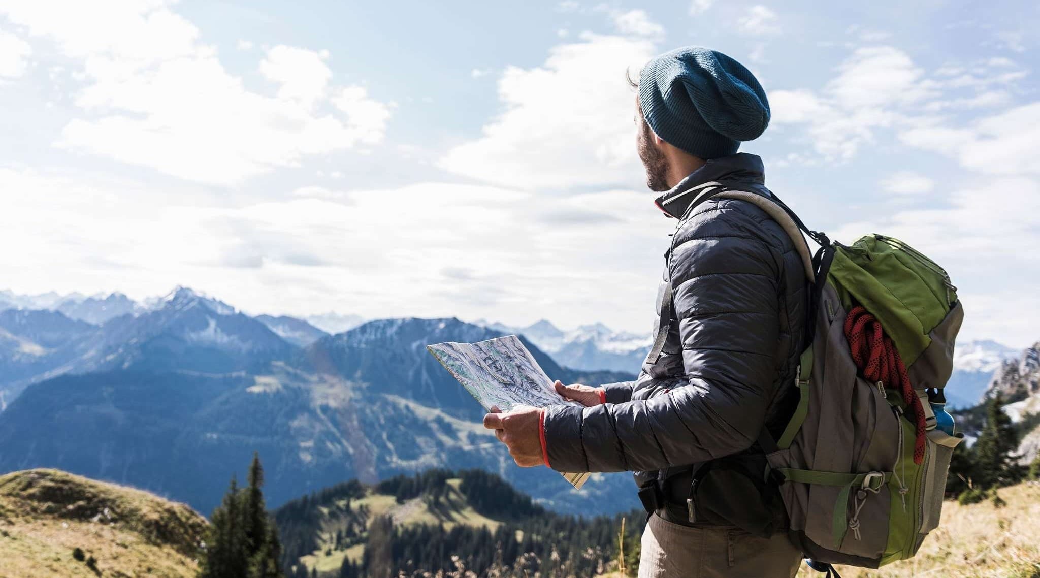 man on a mountain with map