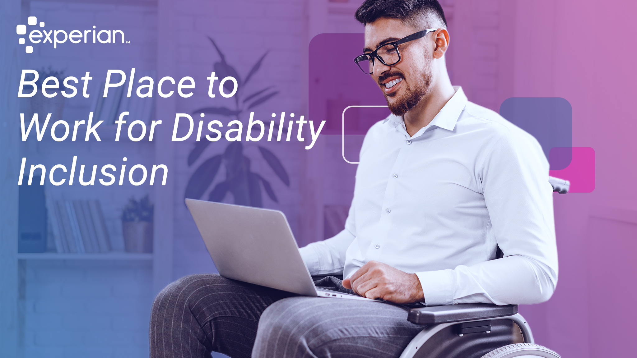 Man in a wheelchair smiles while working on his laptop.