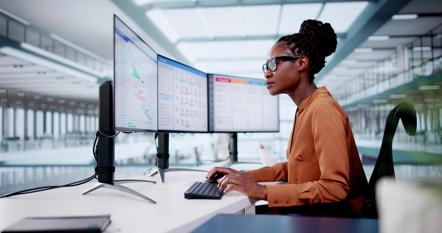 Black woman in orange shirt in a bright modern office