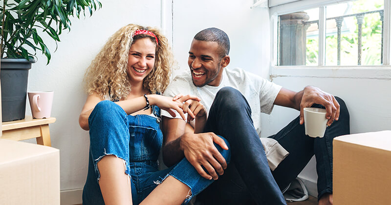 couple holding drinks in new house