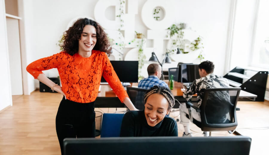A transgender woman working in an office alongside her fellow coworkers